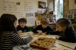 Children collaborating on Breton word puzzles in a warmly lit, heritage classroom in Quimper, captured candidly during an authentic school activity.
